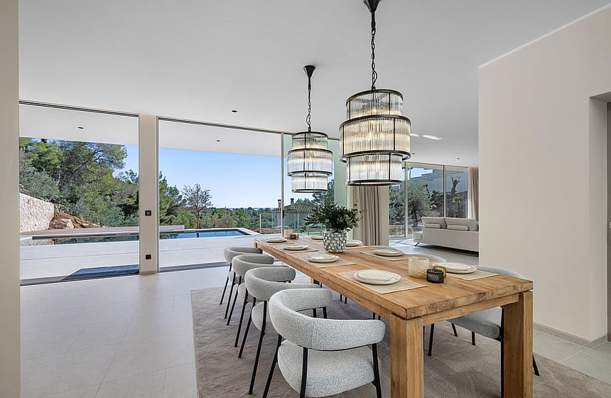 Dining room with statement pendants and retractable glass wall to the pool terrace