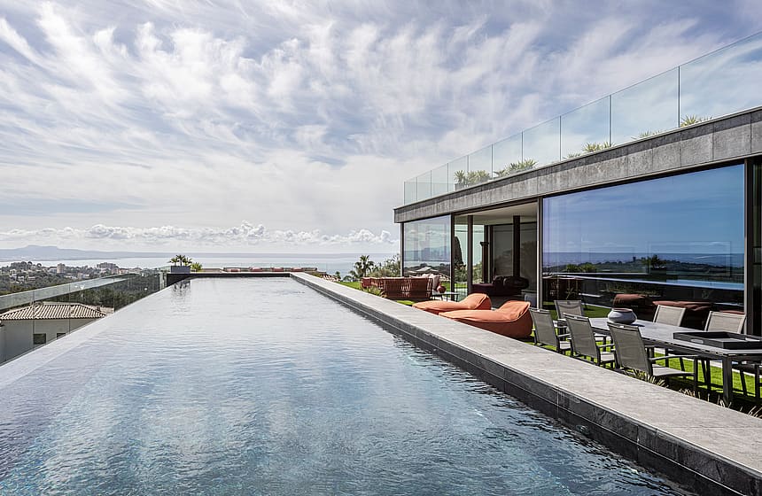 Panoramic view of a sixteen-metre infinity-edge pool overlooking the Bay of Palma, adjacent to a modern terrace.