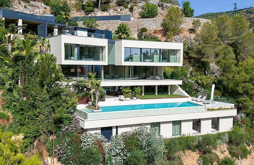 Exterior view of a multi-level contemporary villa in Son Vida, featuring a rectangular infinity pool and terraced levels.