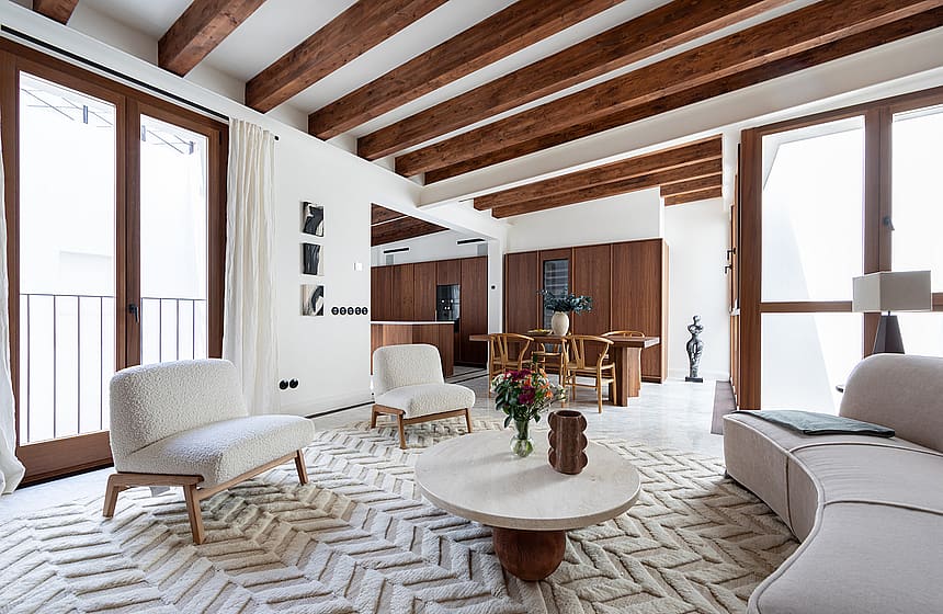 Original Mallorquín floor tiles, exposed beams and double balconies open the lower level to the rhythm of the street.