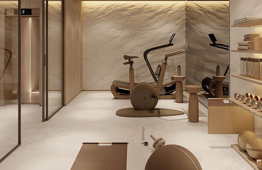 A minimalist home gym featuring a stationary bike, yoga mat, and balance ball, with textured stone walls and recessed lighting.