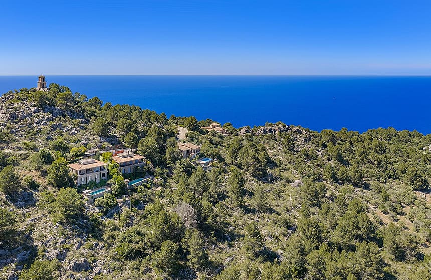 Aerial view of George Sand Villa nestled in the pine-covered hills of Valldemossa overlooking the Mediterranean Sea.