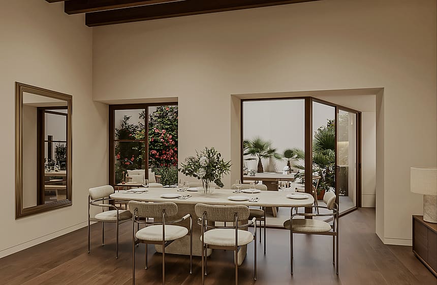 Dining table with eight chairs beside large windows and glazed doors overlooking a planted garden with bougainvillea and palms.