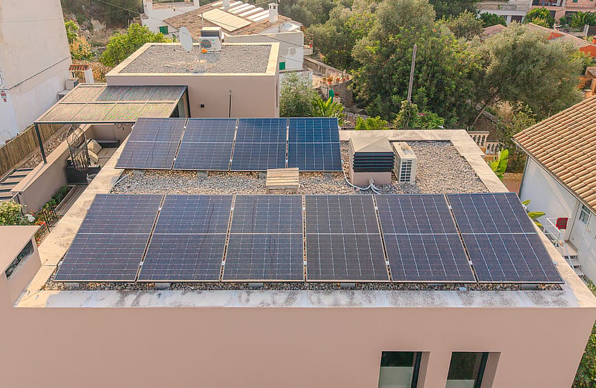 Aerial view of a flat rooftop featuring a modern solar panel array in a residential setting in Genova.