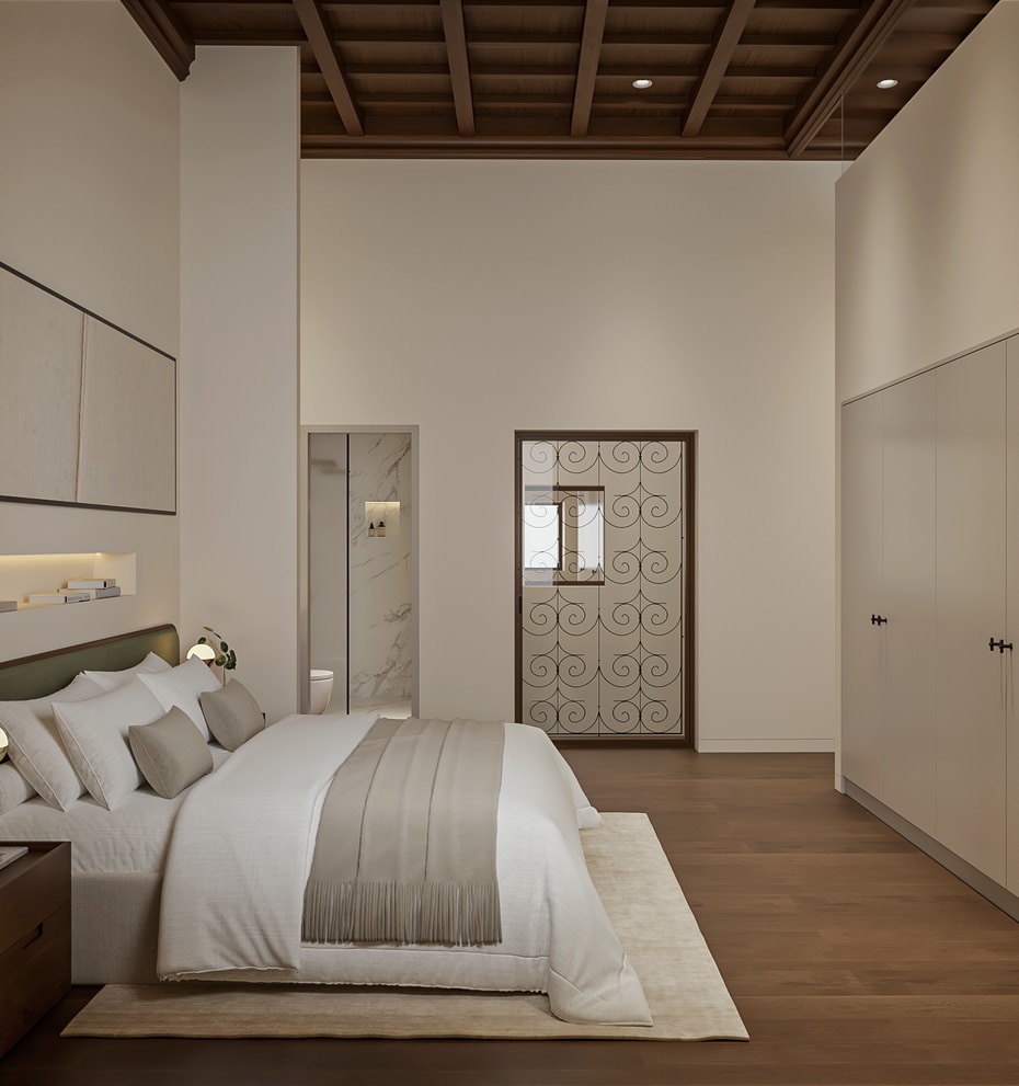 Principal bedroom with green upholstered headboard, coffered wooden ceiling, fitted wardrobes and an en-suite with marble shower through the doorway.