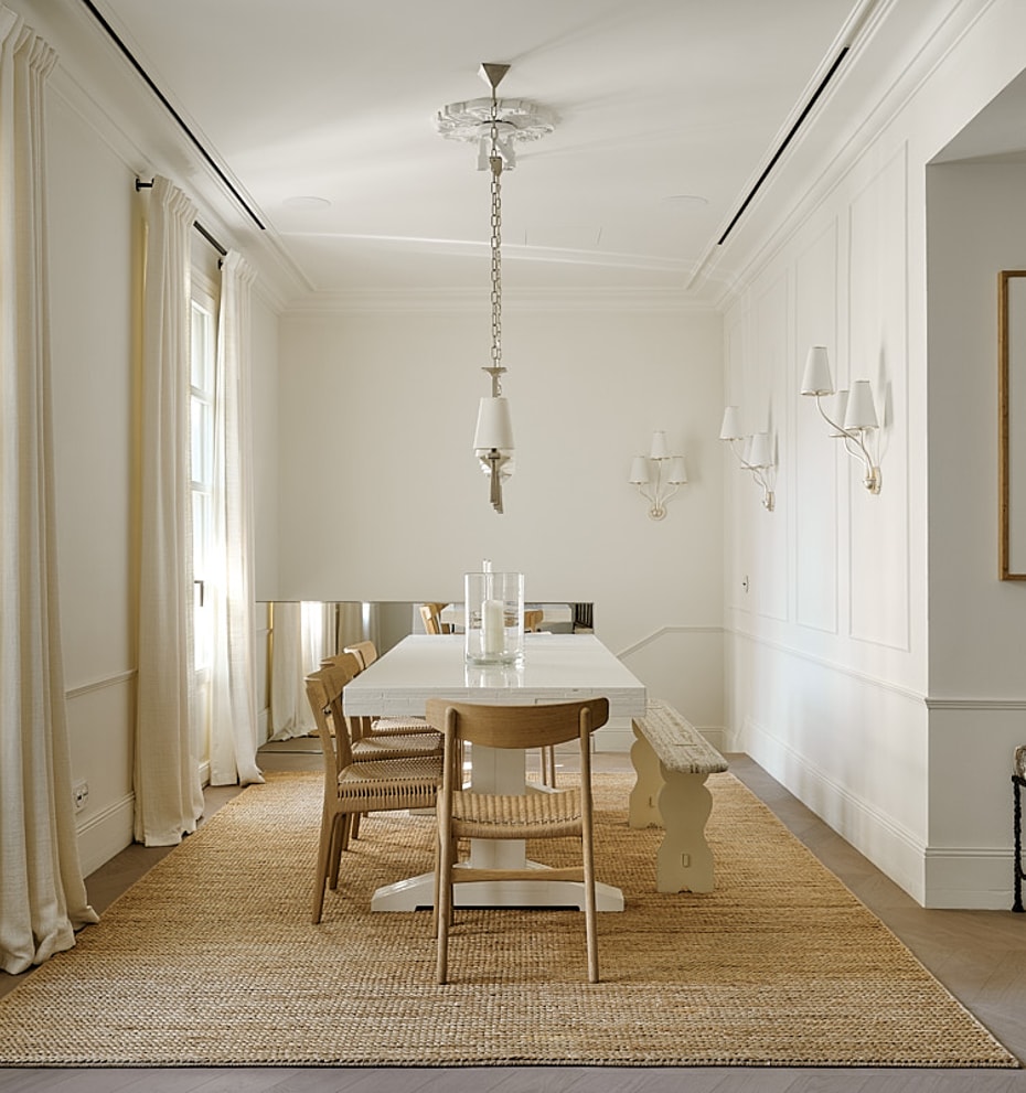 Expansive dining gallery with high ceilings, wooden floor, natural linen seating, windows along full length, and jute rug