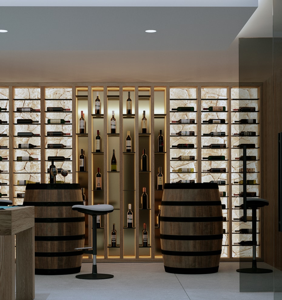 A modern wine cellar featuring backlit stone display walls, two wooden wine barrels used as tables, and bar stools.