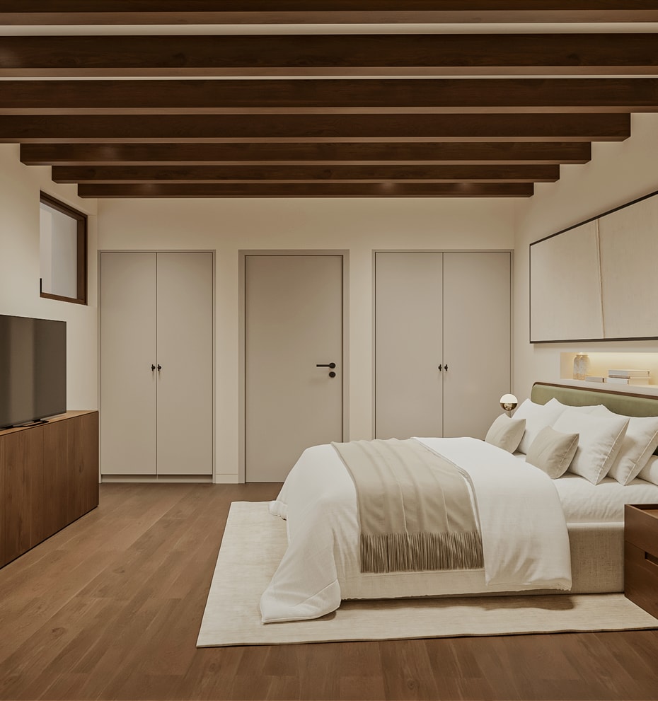 Double bedroom with green upholstered headboard, beamed ceiling, fitted wardrobes and an open door revealing a staircase with iron balustrade.