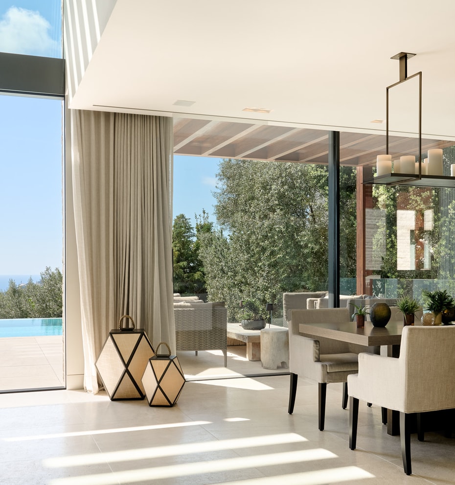 Open-plan living and dining room with natural-toned furnishings and large glazing