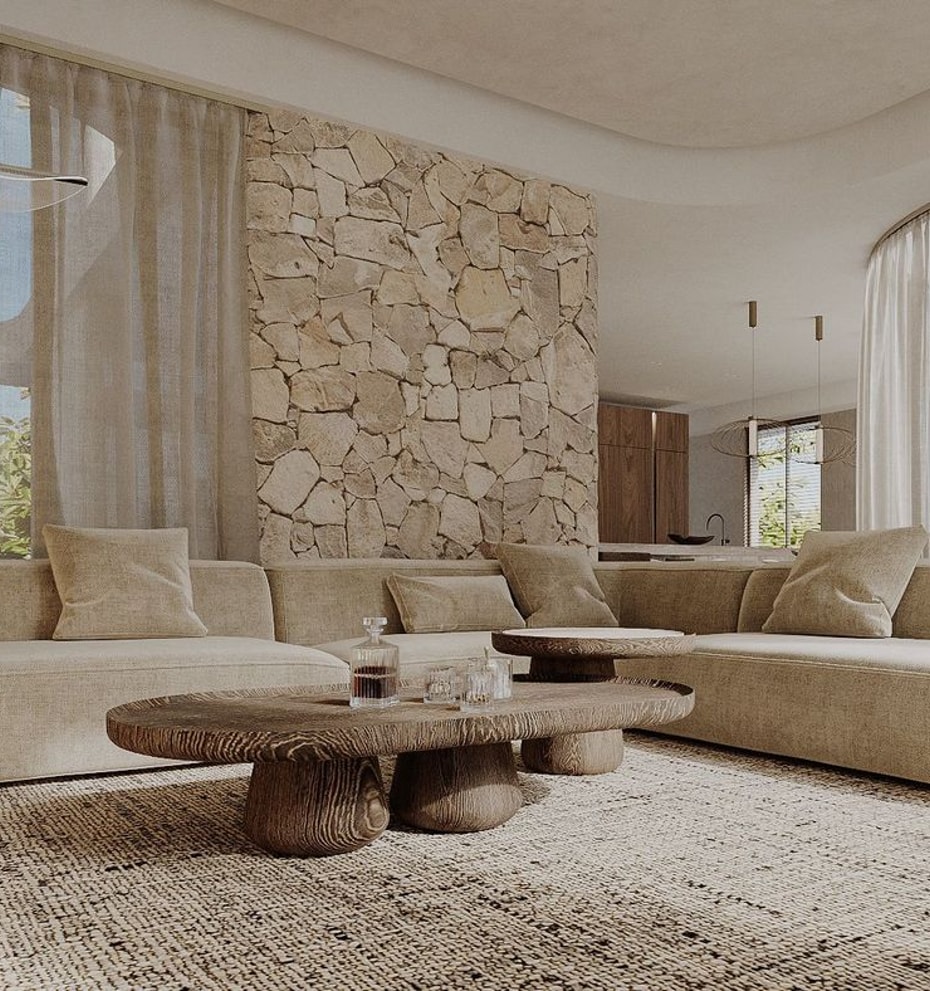 Modern living room with a large beige sectional sofa, a carved wood coffee table, and a feature wall made of round stone logs.