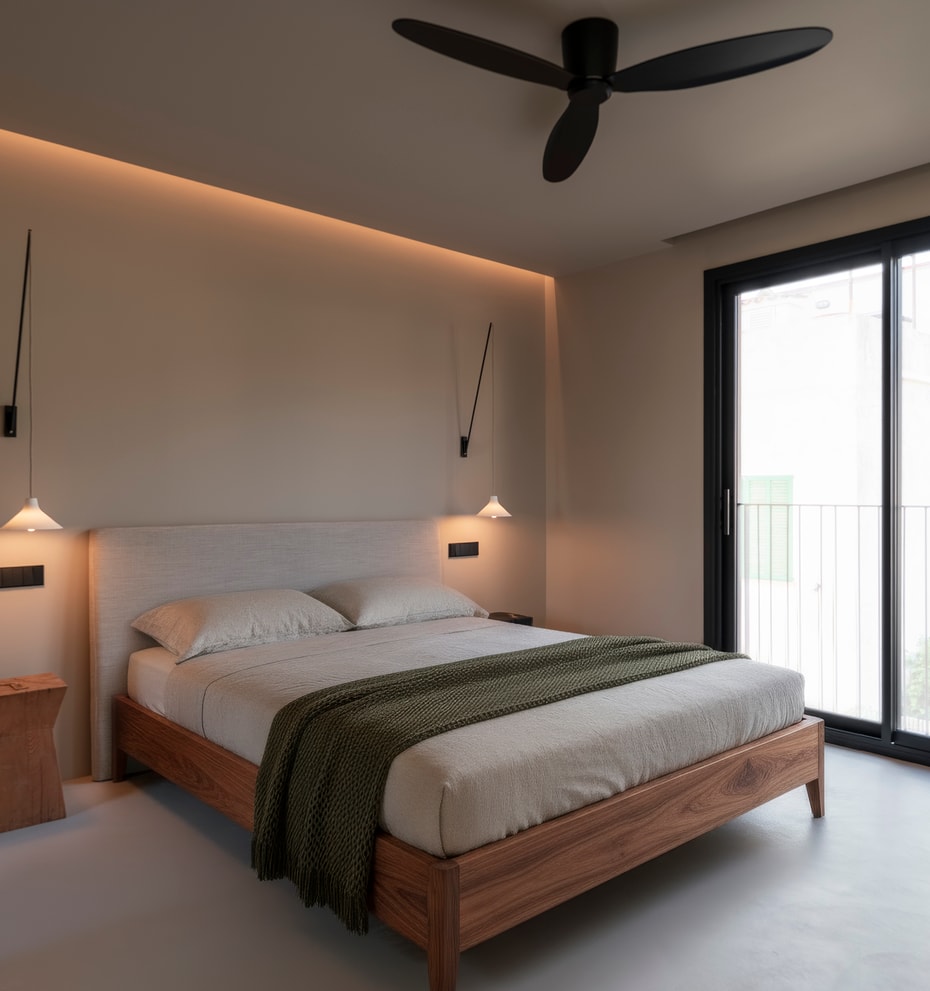 Minimalist bedroom featuring a wooden bed frame, floor-to-ceiling glass doors, and recessed ceiling lighting.