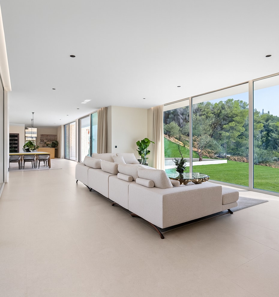 Spacious living area with oversized sectional sofa and full-height sliding glass to pool terrace